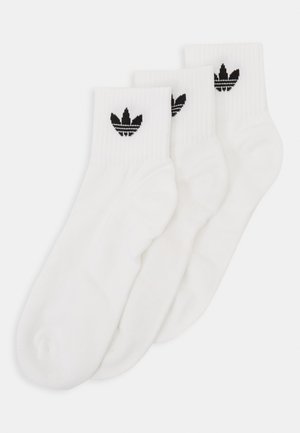 Baltas potītes zeķes ar ribotu apakšmalu un izšūtu melnu Adidas trefoilu logo. Iekļautas trīs zeķu pāri. Mīksts kokvilnas materiāls.