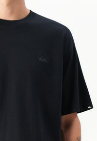 T-shirt preto de mangas curtas feito em algodão. Apresenta um pequeno logótipo em relevo no peito e uma etiqueta com o logótipo na manga. Corte regular.