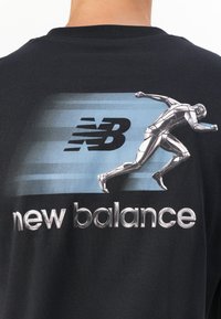 Black t-shirt featuring a blue gradient background with a silver running figure and "new balance" text in metallic lettering.