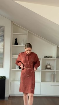 Rust-colored, fitted two-piece set featuring a button-up shirt with jewel accents and a matching knee-length skirt with embellishments.