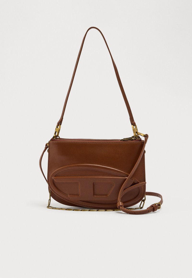 Καφέ δερμάτινη τσάντα χιαστί με λεία υφή, κυρτό μπροστινό σχέδιο και δύο ορθογώνιες λεπτομέρειες. Διαθέτει μακρύ, ρυθμιζόμενο λουρί.