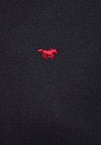 Navy cotton t-shirt featuring a small red embroidered horse logo on the left chest area. Smooth, lightweight fabric with a classic cut.