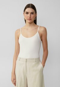 Witte spaghetti strap bodysuit met een ronde hals. Smooth, lichtgewicht stof in combinatie met beige hoge taille broek voor een casual look.