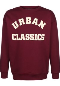 Bordová mikina s nápisem "URBAN CLASSICS" velkým krémovým písmem na hrudi, vyrobená z měkké tkaniny s žebrovanými manžetami a lemem.