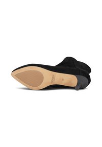 Stivaletto in suede nero con tacco in gomma texture e punta liscia e rotonda. La suola è beige con una zona di presa decorata e il marchio.