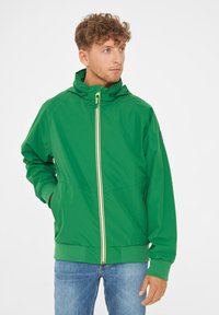 Green nylon jacket with a hood, front zipper closure featuring a contrasting yellow stripe, and elastic cuffs and hem. Casual design.