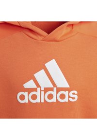 Felpa arancione con cappuccio, caratterizzata da un logo Adidas bianco, una texture morbida e una tasca a marsupio, che presenta un design a pullover e cappuccio con coulisse.