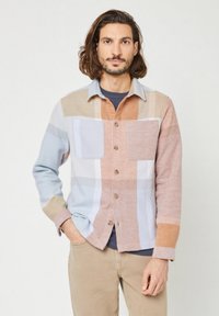 Camicia a scacchi multicolore in morbido tessuto con bottoni, due tasche sul petto e colletto a ribalta. I colori includono azzurro chiaro, beige e pesco.