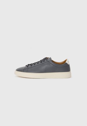 Gray leather sneaker with round toe, rubber sole, flat laces, and light-colored accents on the heel. Smooth texture and minimalist design.