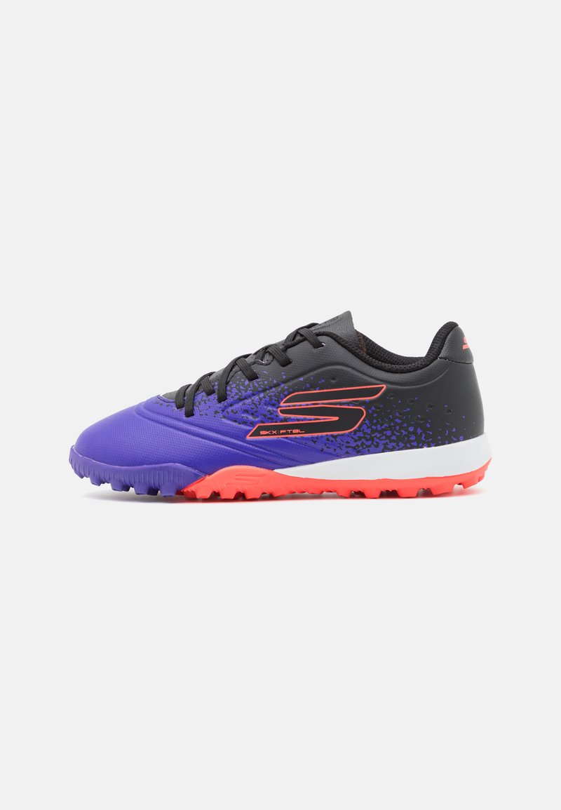 Des crampons de soccer violets et noirs avec une tige texturée, une semelle intermédiaire blanche et une semelle extérieure orange vif ; avec un logo prononcé sur le côté.
