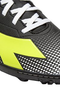 Scarpa da calcio nera e gialla con tomaia testurizzata, motivo a pois, lacci bianchi e suola in gomma con tacchetti per la trazione.