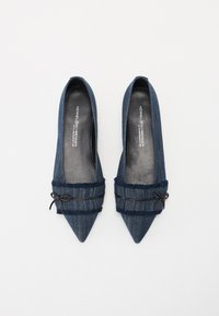 Denim ballerina flats med spiss tå som har en frynset stoffdetalj rundt anklene, knyttet med et svart bånd. Glatt innersåle i mørkegrå.