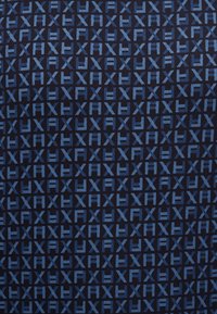 Επαναλαμβανόμενο μοτίβο με μπλε γράμματα "AXY" διατεταγμένα σε πλέγμα σε φόντο σκουρόχρωμου μπλε υφάσματος.