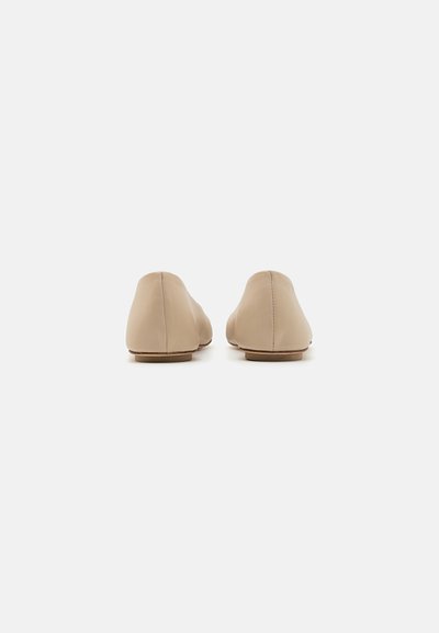 Beige leren ballerina's met een soepele textuur, ronde neus en een laag profiel. De zool is plat en subtiel, wat zorgt voor een minimalistisch ontwerp.