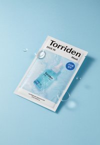 Pakkaus Torriden Maskissa esittelee sinivalkoisen suunnittelun, jossa on seerumipipetti. Pakkaus näyttää tekstin "SUUNNISTA SISÄÄN" sekä vesipisaroita sinisellä taustalla.