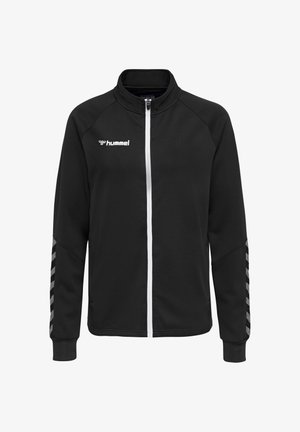 Zwarte sportjas met witte rits, hummel-logo op de borst en reflecterende chevronstrepen op de mouwen.