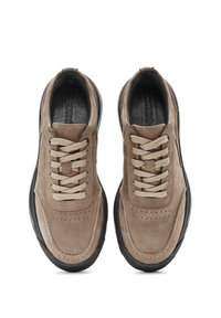 Baskets en suede marron avec une semelle en caoutchouc noire, dotées de lacets beiges, de détails perforés et d'un design épuré.