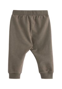Mørkegrønne bomulds sweatpants med elastisk talje og ribkant, der har et drop-crotch design og en glat overflade. Ingen lommer.