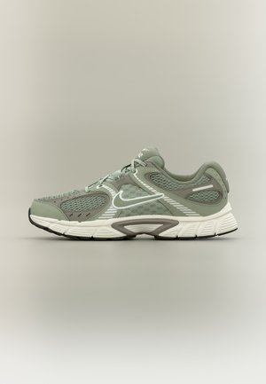 Chaussure de course Nike vert clair et blanc avec empiècements en mesh et synthétiques, semelle blanche et logo Nike visible sur le côté.