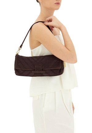 Borsa in tessuto marrone, trapuntata, con chiusura a patta, tracolla corta e dettagli in metallo dorato, esposta su uno sfondo chiaro.