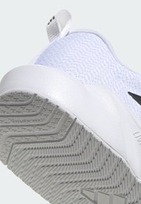 Witte sportschoen met een bovenwerk van mesh, een getextureerde zool met een visgraatpatroon en een opvallende lus aan de hiel voor gemakkelijk aan- en uittrekken.