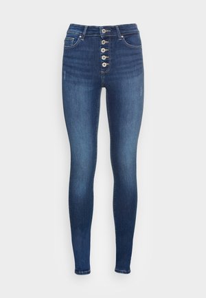 Jeans ajustados de denim azul con una cintura alta, cierre frontal de cinco botones y detalles de costura clásicos. Presenta una textura lisa y sin desgastes visibles.