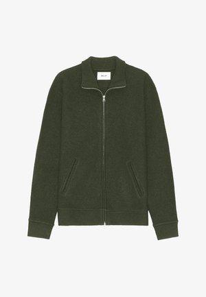 Olivgrön zip-up munkjacka med hög krage, två framfickor, ribbade ärmmuddar och ett slätt, strukturerat tyg. Logomärke inuti kragen.