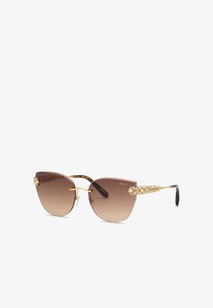 Lunettes de soleil œil de chat dégradé marron avec des branches ornées d’or et des embouts noirs, dotées d’un design sans monture et de plaquettes de nez.