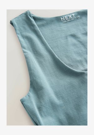 Haut bleu clair à encolure dégagée, fabriqué en tissu doux, présentant un design simple avec une texture lisse et des manches courtes. Étiquette de marque visible.