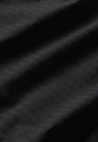 Tissu noir avec une texture à nervures diagonales subtiles ; aspect doux et mat sans motifs ni embellissements supplémentaires.