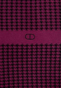 Tkanina s potlačou v štýle houndstooth v ružovej a čiernej farbe. Má hladký povrch a v strede sa nachádza výrazné logo v čiernej farbe.