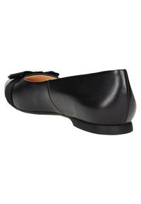 Ballerine in pelle nera con punta arrotondata, texture liscia e un adorabile fiocco sulla parte anteriore. Suola sottile con tacco leggermente rialzato.