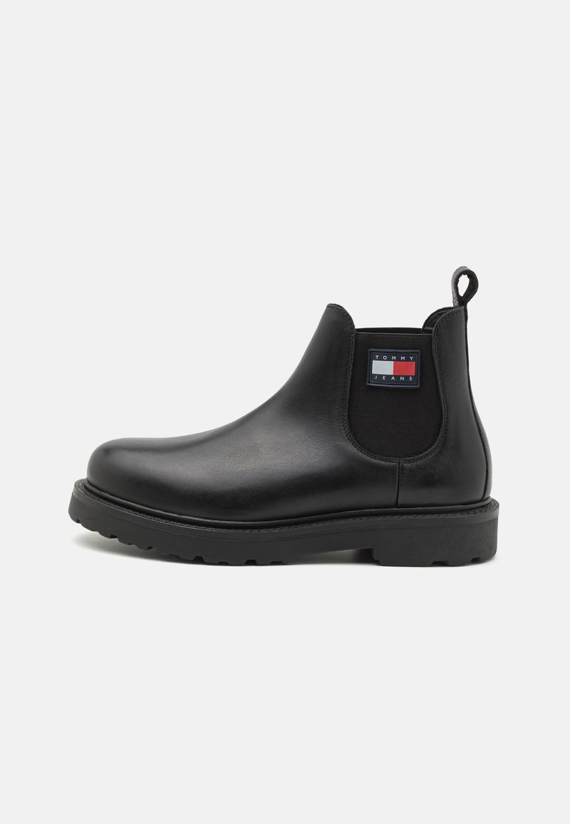 Bottines chelsea en cuir noir avec panneaux élastiques et une languette. Semelle en caoutchouc épaisse avec motif de traction ; comprend un patch logo de marque.