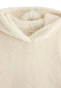 Felpa con cappuccio color crema realizzata in tessuto morbido e peloso. Caratterizzata da una texture accogliente con un profondo scollo e bordi arrotondati e soffici.