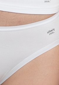 Witte katoenen slips met een gladde textuur, voorzien van een tailleband en de tekst "softfeeling" en "SPIEDEL" in het zwart gedrukt. Minimalistisch ontwerp.