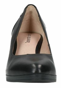 Pompe en cuir noir avec un bout rond, un côté découpé et une texture lisse. L'intérieur présente une semelle beige avec la marque "No Stiletto".