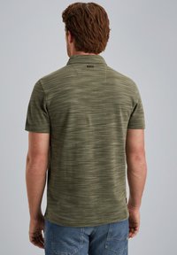 Polo shirt vert olive à manches courtes, en tissu texturé avec des rayures horizontales subtiles, et une petite étiquette avec logo au col.