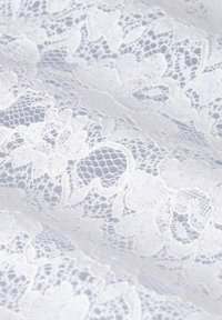 White lace fabric featuring floral patterns, intricate detailing, and a delicate texture. The design includes open weaves and scalloped edges.
