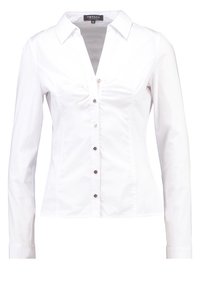 Weiße Langarmbluse mit V-Ausschnitt, Knopfleiste und tailliertem Design. Hergestellt aus glattem Stoff, mit dezenten Nahtdetails und silbernen Knöpfen.
