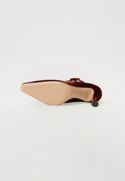 Chaussure à talon aiguille avec un bout pointu, dessus lisse bourgogne et semelle en caoutchouc beige. Présente une boucle décorative sur la bride.