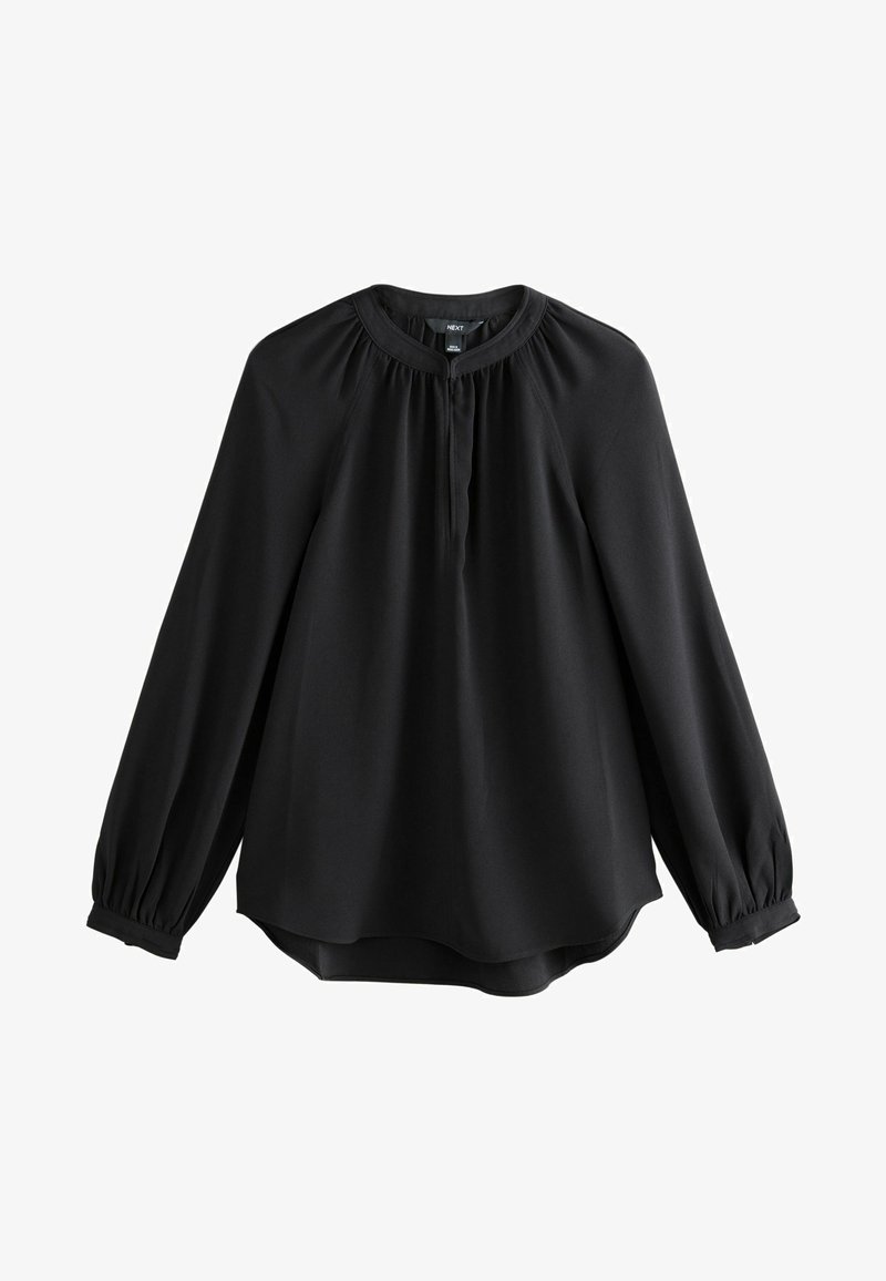 Blouse noire à manches longues avec encolure ronde, empiècement froncé, patte de boutonnage cachée à l'avant et poignets boutonnés, posée à plat sur un fond blanc.