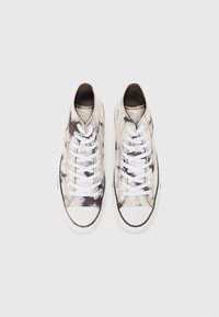 Canvas high-top sneakers in a light-toned tie-dye pattern, featuring white laces and black rubber soles with a reinforced toe cap.