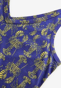 Canotta viola con motivo a scampi gialli, realizzata in tessuto morbido dalla texture liscia, progettata con spalline larghe.