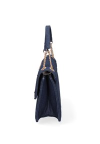 Denim tote bag with a structured shape, featuring a gold chain strap, folded top, and a deep blue color. Exposed stitching detail visible.