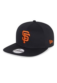 Gorra de béisbol negra con el logo naranja "SF" en la parte delantera, visera plana y diseño de seis paneles. Cuenta con cierre ajustable tipo snapback y etiqueta de marca en la visera.