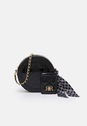 Sac à main rond noir brillant avec bandoulière chaîne dorée, petit porte-monnaie assorti avec logo doré, et foulard en soie à motifs noir et blanc.