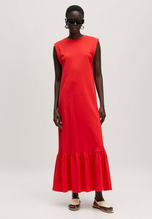 Robe maxi sans manches rouge avec une jupe évasée, fabriquée en tissu doux. Le design présente un col rond et une silhouette longue et fluide.