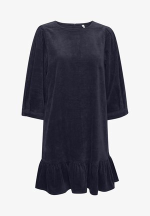 Tumedate sinine kõrvitsakleidiga, millel on kolmandiku pikkuse varrukad, ümar kaelus ja rulliga äär. Tekstureeritud kangas omab vertikaalset ribastust.