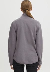 Grijze fleecetruien met hoge kraag, lange mouwen en een rechte zoom. Het oppervlak heeft een zachte, geperste afwerking met een minimalistisch ontwerp.