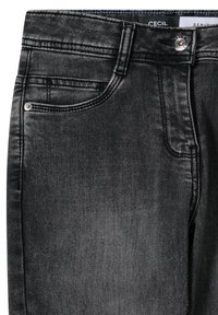 Czarne dżinsy z denimu, zbliżenie pokazujące przednią kieszeń, szlufki na pasek, zapięcie na guzik oraz metkę marki "Cecil" wewnątrz paska w talii.